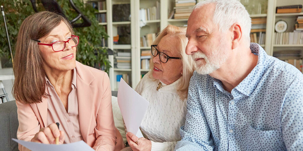 Drei ältere Menschen schauen auf ein Dokument